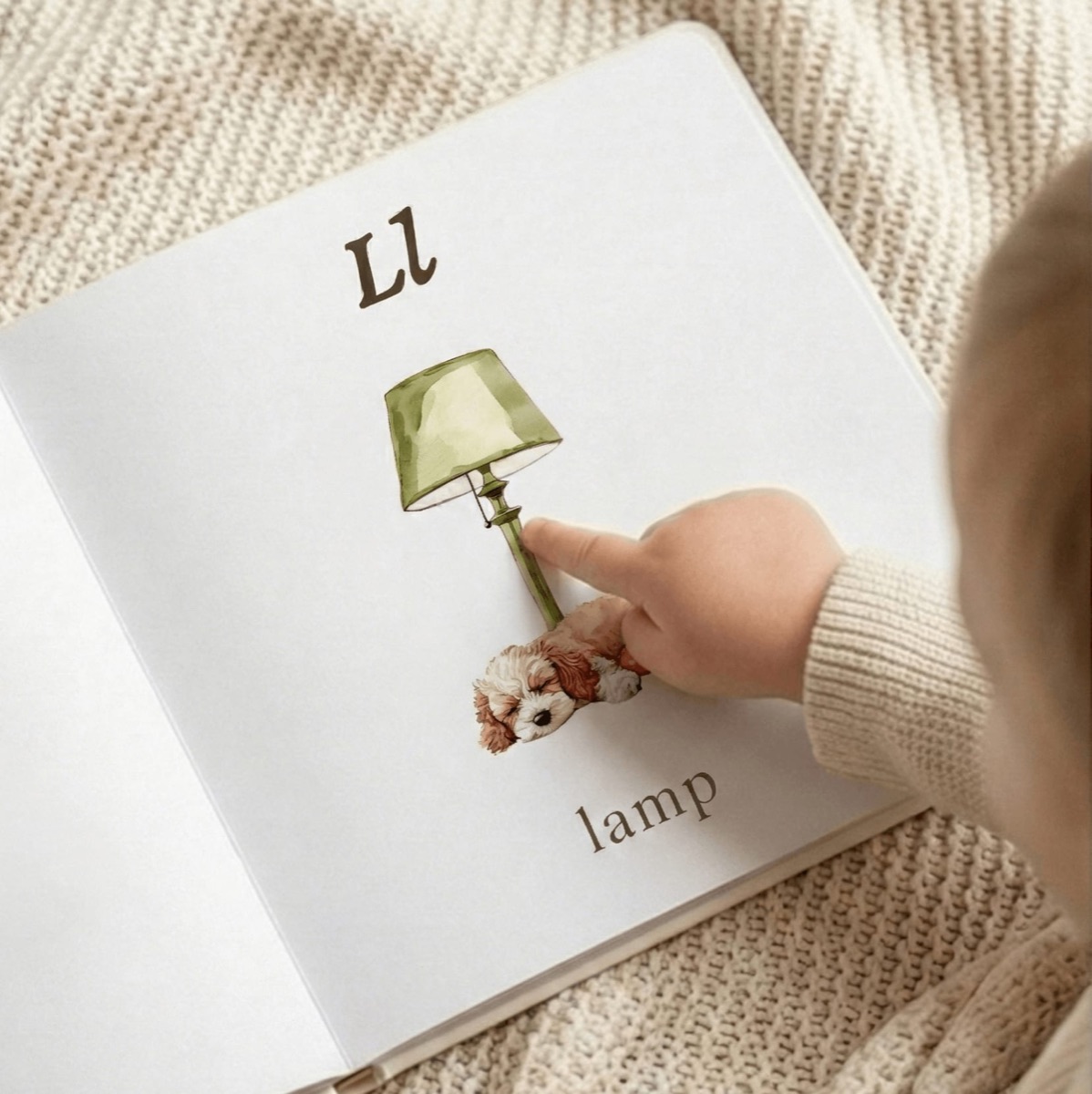 A toddler pointing at the letter L page of the ABC book